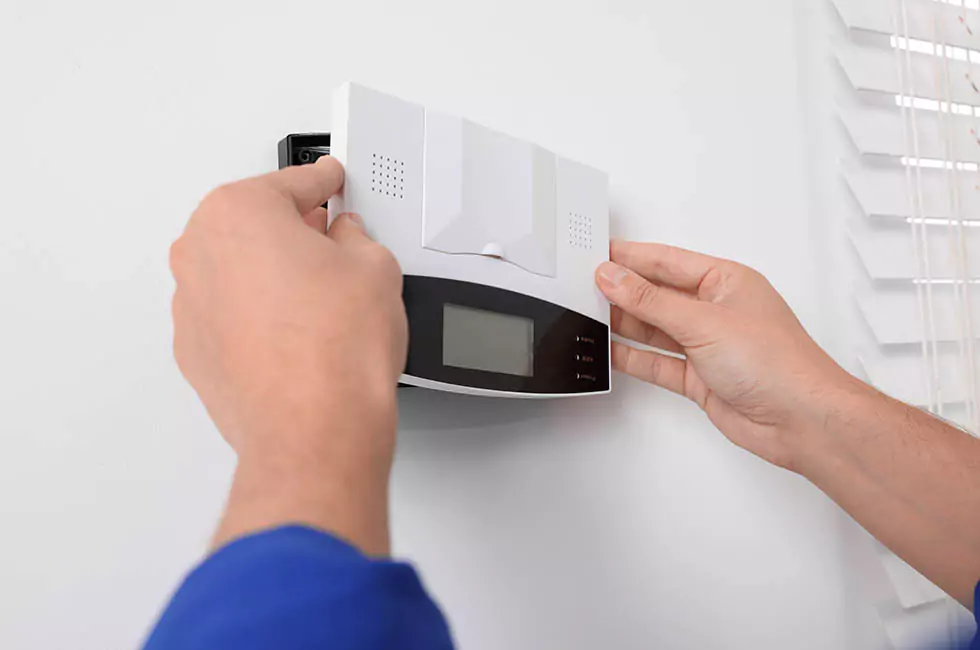 shutterstock-2394875335-68ac2e019a156 Eine Sprechanlage wird an eine weiße Wand montiert.